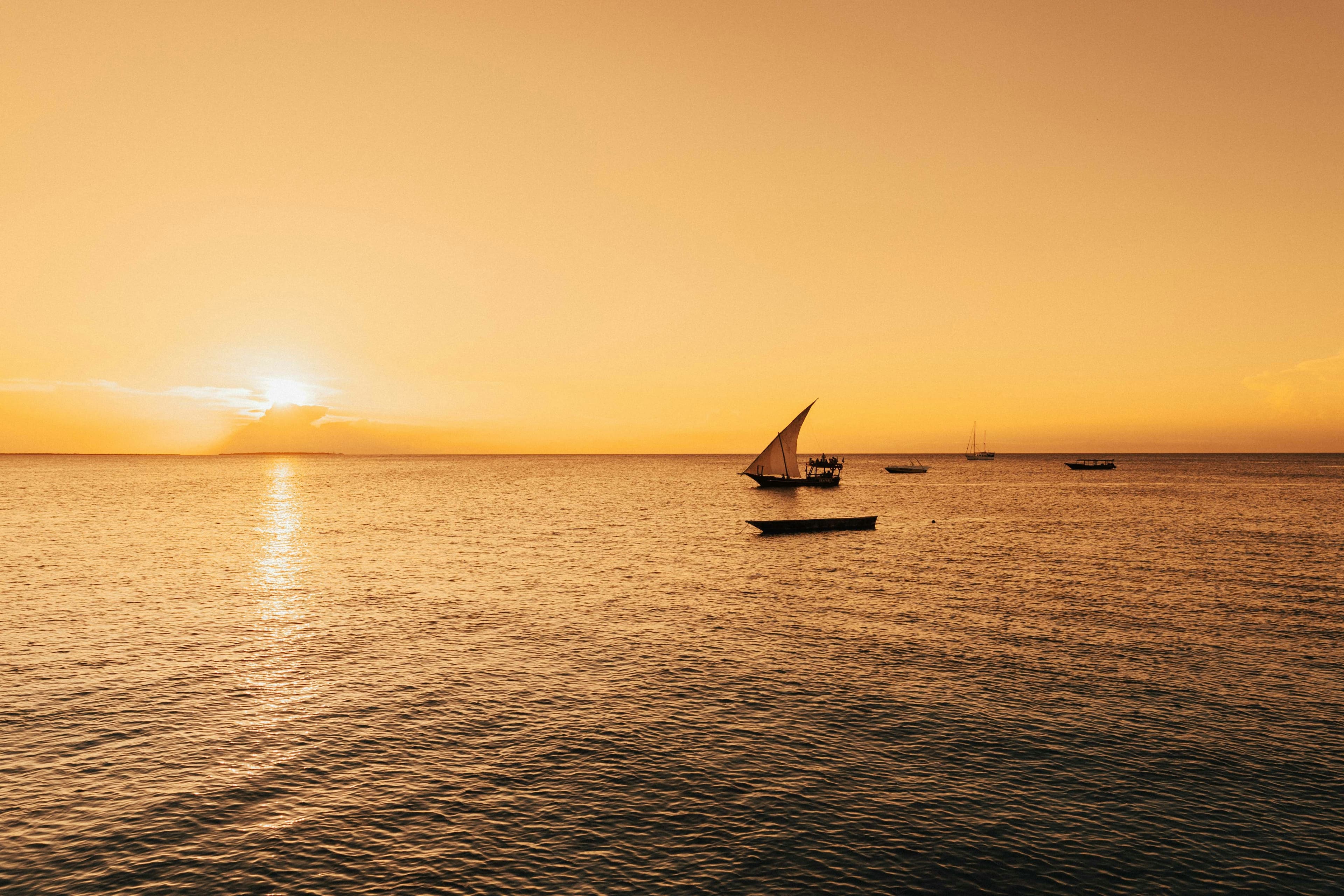 A private dhow under sail at sunset, off the coast of Zanzibar