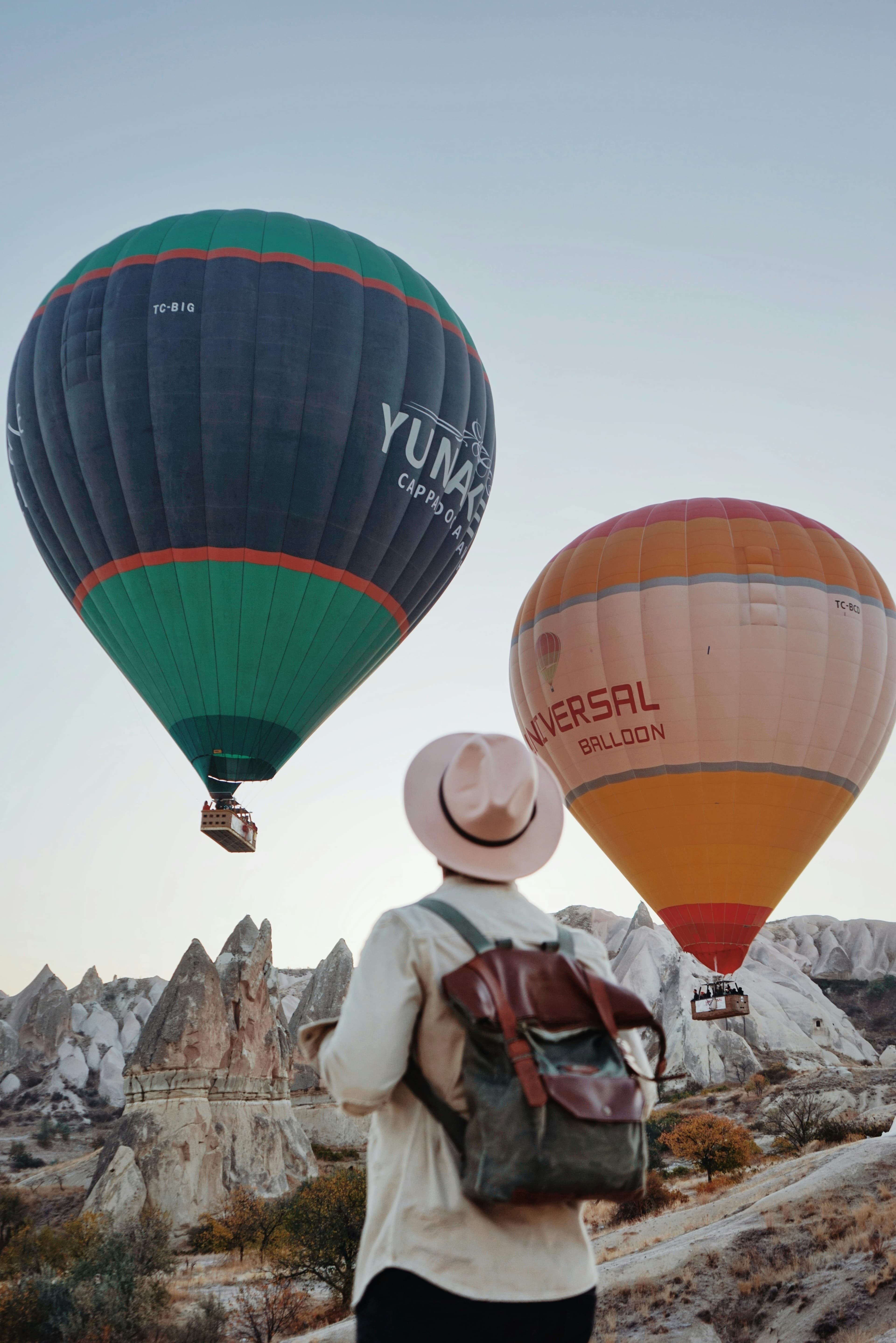 A traveller watching hot air balloons lift off over Cappadocia at dawn