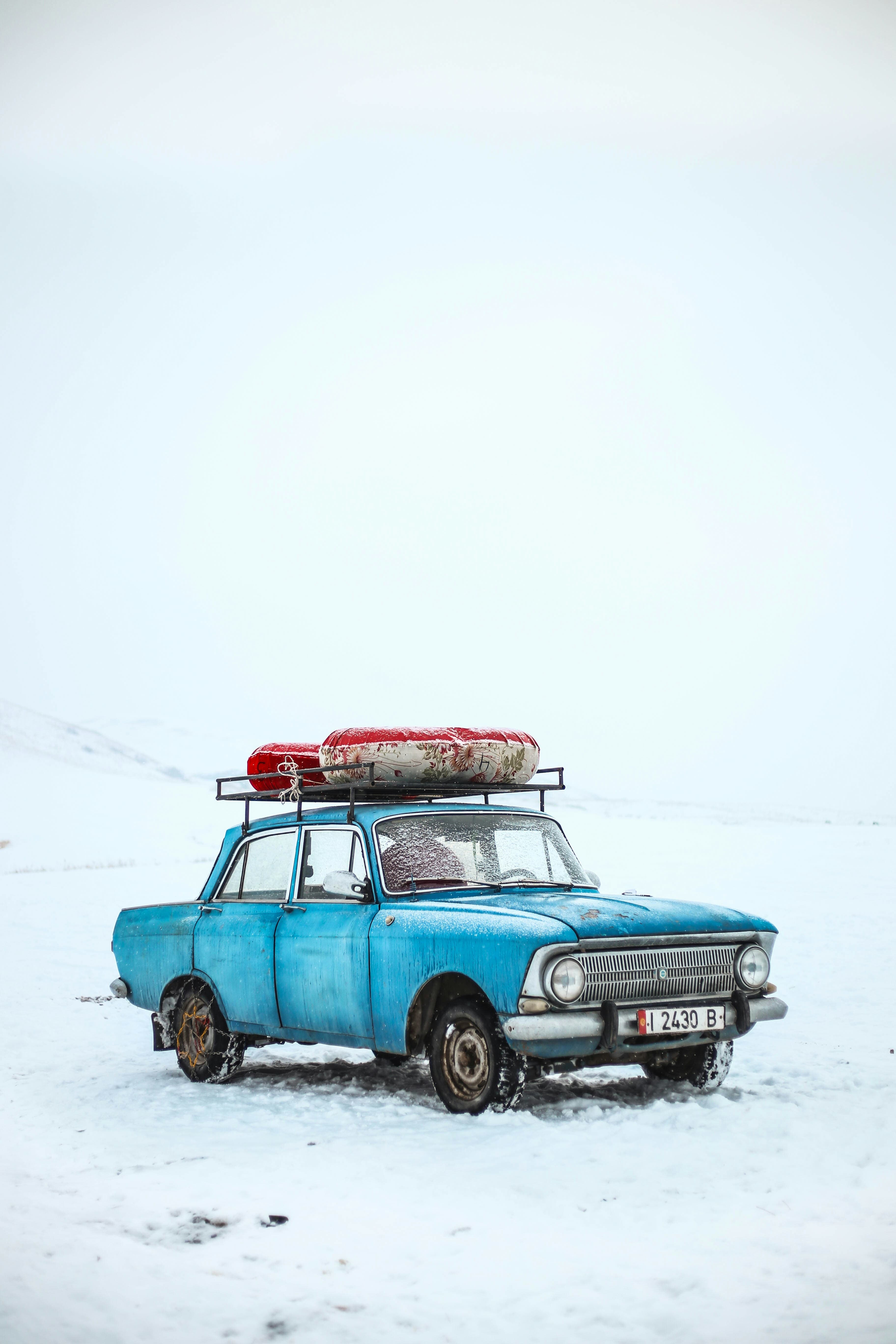 An old estate car loaded for a journey, parked on open snow