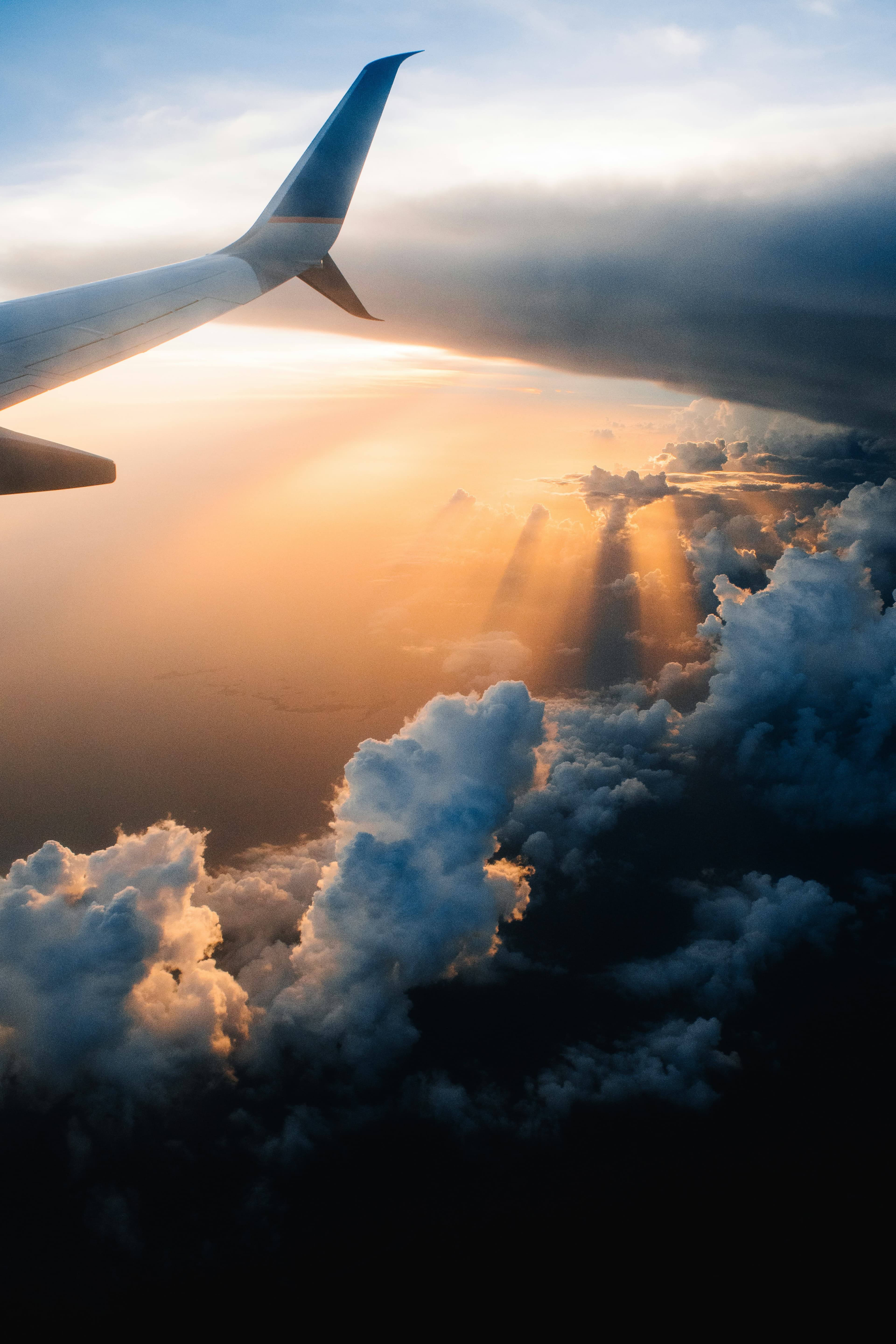 An aircraft wing above a bank of clouds
