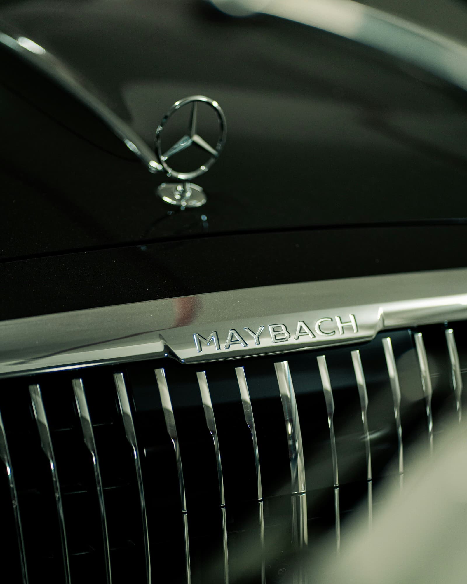 A Mercedes Maybach hood ornament and grille badge